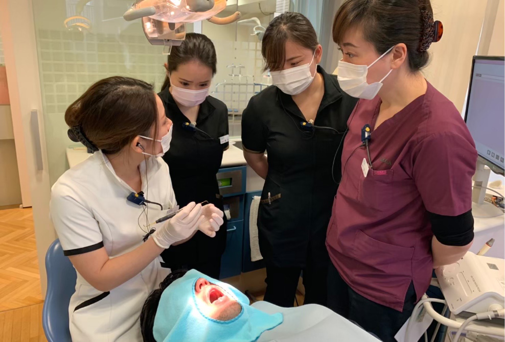 歯科衛生士がセミナー内容をスタッフに実習形式で共有している風景