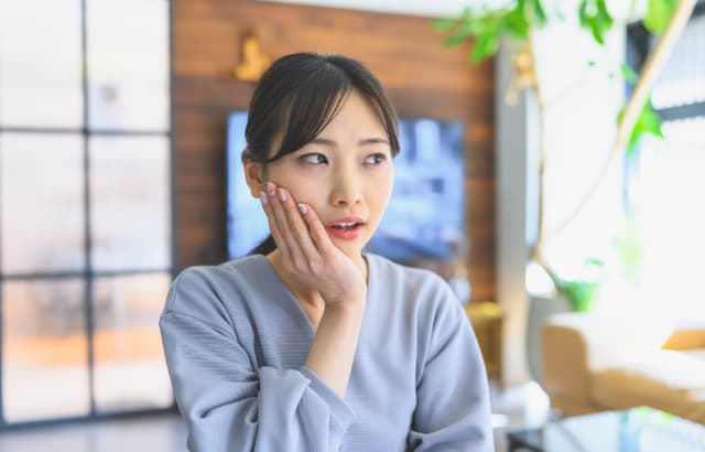 インプラント手術後に痛みを感じる女性